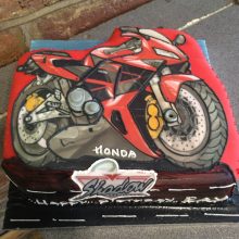 Personalised photo cake featuring a photo of a red Honda motorbike.