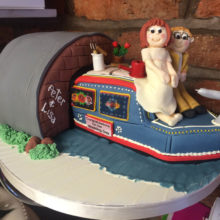 A wedding cake resembling a boat including two icing figures on top. The cake is on display in a cake shop in Wolverhampton.