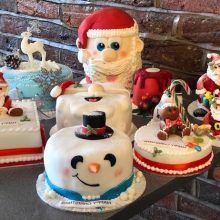 A selection of bespoke Christmas cakes sitting on a table.